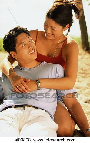 Stock Photo - Young couple embracing, looking at each other. Fotosearch