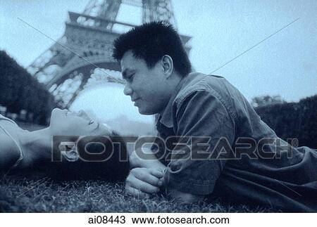 Young couple lying on grass, Eiffel Tower in background. View Large Photo Image Stock Image - Young couple lying on grass, Eiffel Tower in background.. Fotosearch