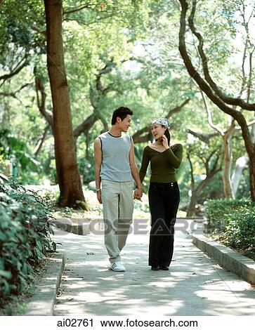 Young couple walking down path holding hands, nature in background. View Large Photo Image Stock Image - Young couple walking down path holding hands, nature in background.. Fotosearch