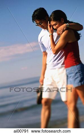 Young couple walking on beach, embracing View Large Photo Image Stock Image - Young couple walking on beach, embracing. Fotosearch