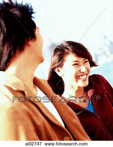 Young couple with city skyline behind, woman smiling. View Large Photo Image Stock Photo - Young couple with city skyline behind, woman smiling.. Fotosearch