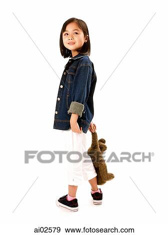 Stock Photo - Young girl holding teddy bear, white background.. Fotosearch