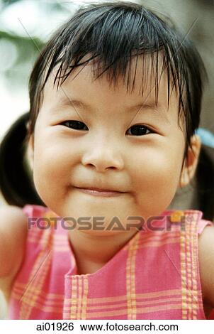 Stock Photograph - Young girl in pink dress, portrait. Fotosearch