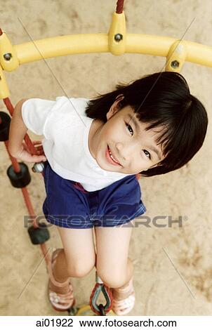 Young girl playing in jungle gym, elevated view View Large Photo Image Stock Image - Young girl playing in jungle gym, elevated view. Fotosearch