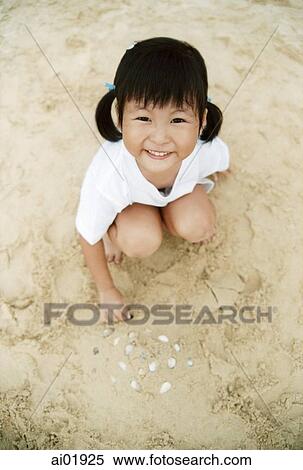 Young girl playing in the sand, elevated view View Large Photo Image Stock Photography - Young girl playing in the sand, elevated view. Fotosearch