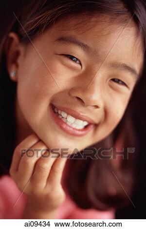 Picture - Young girl smiling with hand on chin. Fotosearch