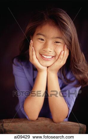Young girl smiling with hands on chin View Large Photo Image Stock Photo - Young girl smiling with hands on chin. Fotosearch