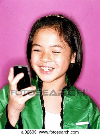 Young girl using cellular phone, smiling, purple background. View Large Photo Image Stock Image - Young girl using cellular phone, smiling, purple background.. Fotosearch