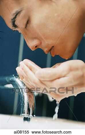 Young man cleansing face with water. View Large Photo Image Stock Photography - Young man cleansing face with water.. Fotosearch