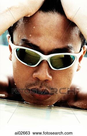Young man emerging from water with sunglasses View Large Photo Image Stock Image - Young man emerging from water with sunglasses. Fotosearch