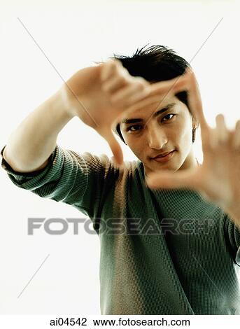 Young man looking through fingers. View Large Photo Image Stock Image - Young man looking through fingers.. Fotosearch