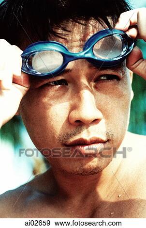 Young man removing swimming goggles View Large Photo Image Stock Photo - Young man removing swimming goggles. Fotosearch