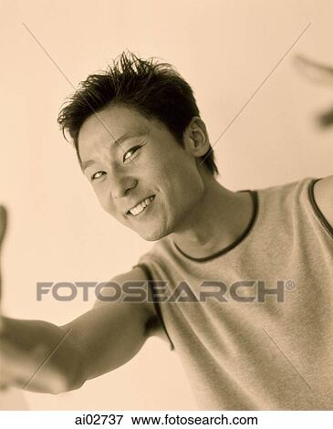 Young man smiling and gesturing to camera. View Large Photo Image Stock Photo - Young man smiling and gesturing to camera.. Fotosearch