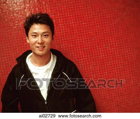 Young man smiling, orange/red background. View Large Photo Image Stock Photo - Young man smiling, orange/red background.. Fotosearch