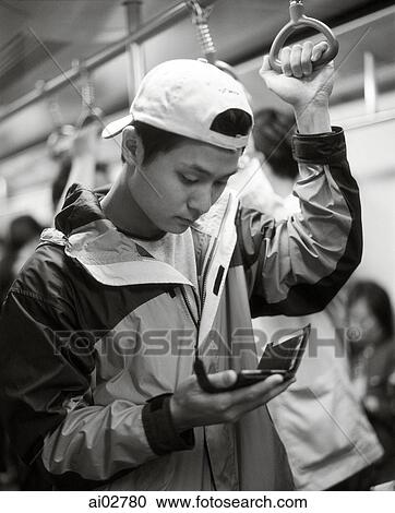 Young man using PDA on train. View Large Photo Image Stock Image - Young man using PDA on train.. Fotosearch