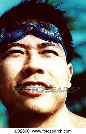 Young man with swimming goggles on head View Large Photo Image Stock Image - Young man with swimming goggles on head. Fotosearch
