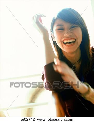 Young woman gesturing and laughing, portrait. View Large Photo Image Stock Image - Young woman gesturing and laughing, portrait.. Fotosearch