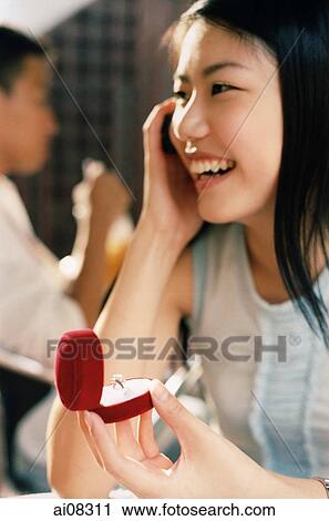 Young woman holding mobile phone and ring, smiling. View Large Photo Image Stock Image - Young woman holding mobile phone and ring, smiling.. Fotosearch