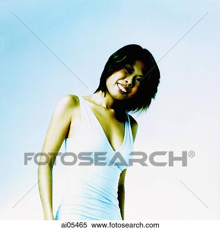 Young woman in white dress against light blue background View Large Photo Image Stock Photography - Young woman in white dress against light blue background. Fotosearch