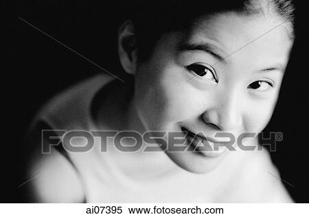 Stock Photography - Young woman looking up, smiling, elevated view. Fotosearch