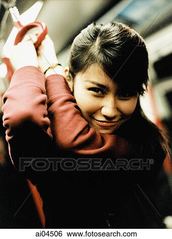 Young woman on train holding on to handle ring, portrait. View Large Photo Image Stock Photograph - Young woman on train holding on to handle ring, portrait.. Fotosearch