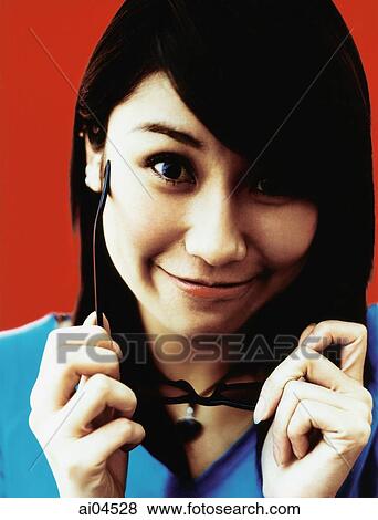 Young woman removing sunglasses, red background. View Large Photo Image Stock Photo - Young woman removing sunglasses, red background.. Fotosearch