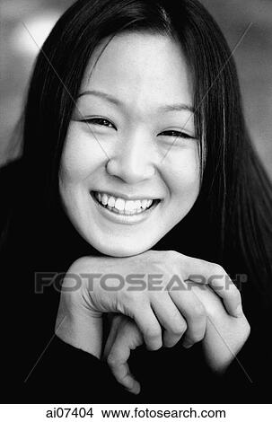 Young woman resting chin on hands, smiling. View Large Photo Image Picture - Young woman resting chin on hands, smiling.. Fotosearch