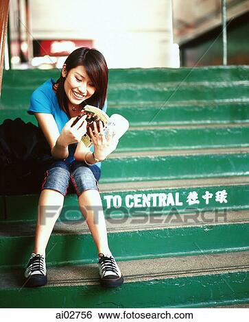 Young woman sitting on steps, reading book. View Large Photo Image Stock Photograph - Young woman sitting on steps, reading book.. Fotosearch