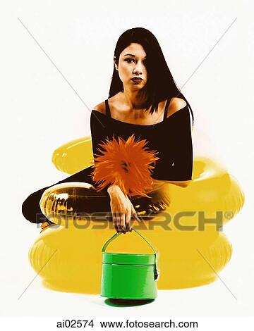 Young woman sitting on yellow inflatable chair, holding green purse View Large Photo Image Picture - Young woman sitting on yellow inflatable chair, holding green purse. Fotosearch