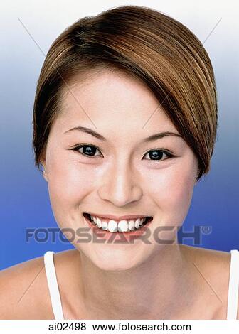 Young woman smiling, blue background, portrait View Large Photo Image Stock Photo - Young woman smiling, blue background, portrait. Fotosearch