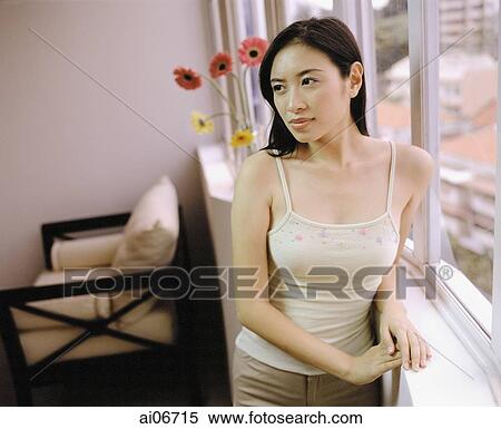 Young woman standing by window. View Large Photo Image Stock Photography - Young woman standing by window.. Fotosearch