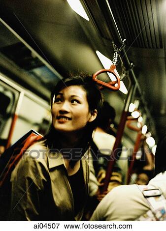Young woman standing in train looking off camera. View Large Photo Image Stock Photo - Young woman standing in train looking off camera.. Fotosearch