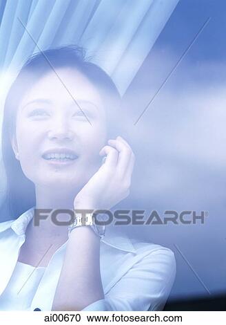 Young woman talking on cellular phone, behind glass window View Large Photo Image Stock Image - Young woman talking on cellular phone, behind glass window. Fotosearch