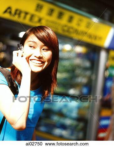 Young woman using cellular phone, shops in background. View Large Photo Image Stock Image - Young woman using cellular phone, shops in background.. Fotosearch