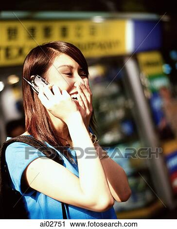 Young woman using cellular phone, laughing, shops in background. View Large Photo Image Stock Image - Young woman using cellular phone, laughing, shops in background.. Fotosearch