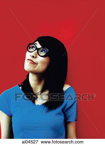 Young woman wearing glasses looking off camera, red background. View Large Photo Image Stock Photo - Young woman wearing glasses looking off camera, red background.. Fotosearch