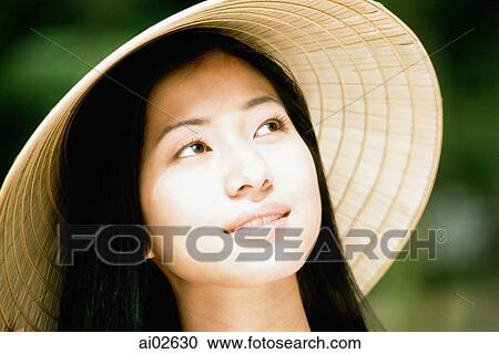 Young woman wearing straw hat, looking up View Large Photo Image Stock Image - Young woman wearing straw hat, looking up. Fotosearch