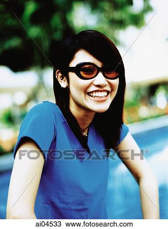 Young woman wearing sunglasses smiling, portrait. View Large Photo Image Stock Image - Young woman wearing sunglasses smiling, portrait.. Fotosearch