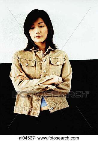Young woman with arms crossed, looking down View Large Photo Image Stock Photo - Young woman with arms crossed, looking down. Fotosearch