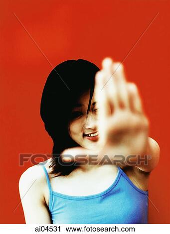 Young woman with hand extended out front, red background. View Large Photo Image Stock Image - Young woman with hand extended out front, red background.. Fotosearch