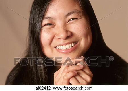 Young woman with hands on chin smiling, portrait View Large Photo Image Stock Image - Young woman with hands on chin smiling, portrait. Fotosearch