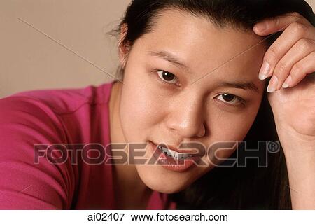 Young woman with head on hand, smiling, portrait View Large Photo Image Stock Photo - Young woman with head on hand, smiling, portrait. Fotosearch