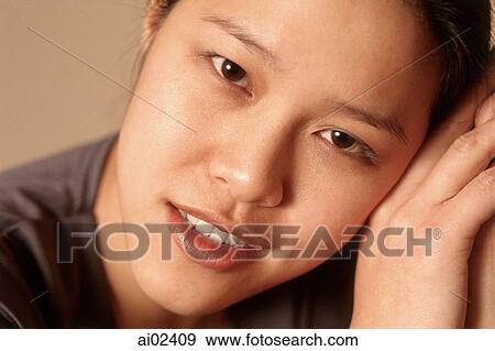 Young woman with head on hands, smiling, portrait View Large Photo Image Stock Photo - Young woman with head on hands, smiling, portrait. Fotosearch
