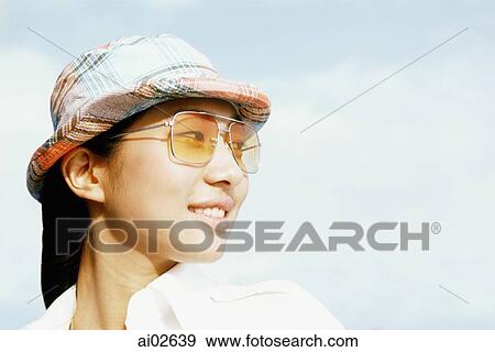 Young woman with patterned hat and sunglasses looking away, white background View Large Photo Image Stock Photo - Young woman with patterned hat and sunglasses looking away, white background. Fotosearch