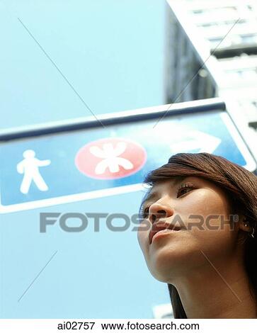 Young woman with signboard and building in background, blue sky View Large Photo Image Stock Photo - Young woman with signboard and building in background, blue sky. Fotosearch