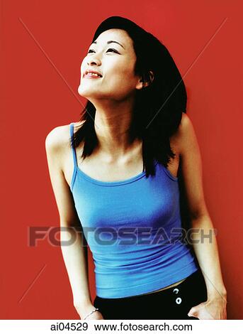 Young woman with thumbs in pocket looking off camera, red background. View Large Photo Image Stock Photo - Young woman with thumbs in pocket looking off camera, red background.. Fotosearch