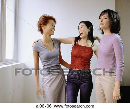 Young women chatting, arms around one another. View Large Photo Image Stock Photograph - Young women chatting, arms around one another.. Fotosearch