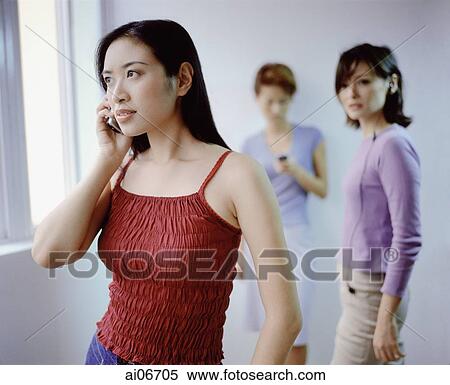 Young women using cellular phones. View Large Photo Image Stock Photography - Young women using cellular phones.. Fotosearch