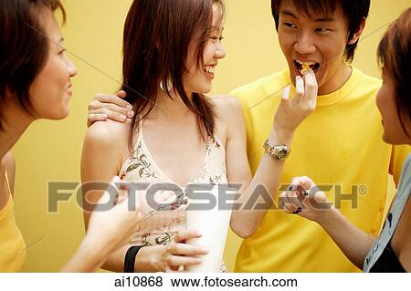 Stock Photo - A group of friends eating ice from a cup. Fotosearch