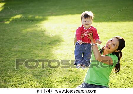 Baby girl being carried up by mother View Large Photo Image Stock Photo - Baby girl being carried up by mother. Fotosearch